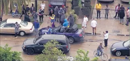 ?? KTLA-TV Channel 5 ?? DOZENS OF PEOPLE emerged from their homes to greet the Mustang driver and his passenger after the chase ended in a South L.A. neighborho­od. The two hugged and high-fived bystanders and took selfies for several minutes before officers arrived to arrest...