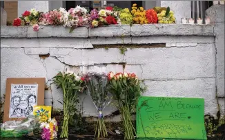  ?? ALYSSA POINTER / ALYSSA. POINTER@ AJC. COM ?? Flowers and signs are displayed at a makeshift memorial outside of the Gold Spa on Wednesday. Three women were killed at the spa the day before.