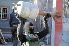  ?? AFP ?? Cleaning up An Iraqi soldier carries a rocket, locally made from domestic gas canisters, from an arms depot of Daesh in the Al Tameem district of Ramadi.