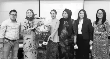  ??  ?? Sharifah Hasidah (second left) receives a memento from Tina during the seminar’s closing ceremony.