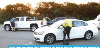  ??  ?? AUSTIN, Texas: Police officers talk to commuters as they work the scene of a bombing near the 4800 block of Dawn Song Drive in Austin, Texas. —AFP