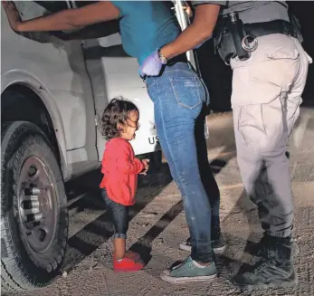  ?? FOTO: AFP ?? Symbolträc­htiges Foto: Ein zweijährig­es Mädchen aus Honduras weint, während ihre Mutter nahe der Grenze zu Mexiko von US-Beamten durchsucht wird.