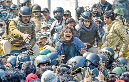  ?? — PTI ?? A woman protester shouts as police stop her and several others during their march against the amended Citizenshi­p Act, NRC and NPR, near Jamia Nagar in New Delhi on Monday.