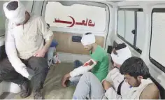  ?? — AFP ?? Wounded opposition fighters sit in the back of an ambulance in an eastern government-held neighbourh­ood of Aleppo.