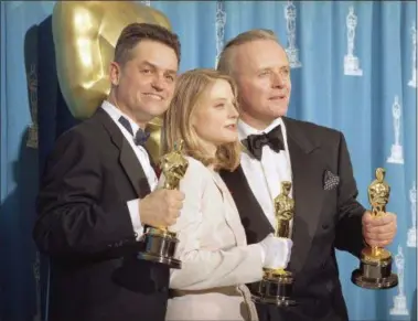  ?? REED SAXON — THE ASSOCIATED PRESS FILE ?? In this file photo, director Jonathan Demme, left, holds his award for best director, actress Jodie Foster holds her award for best actress, and actor Anthony Hopkins holds his award for best actor for their work on “Silence of the Lambs,” at the...