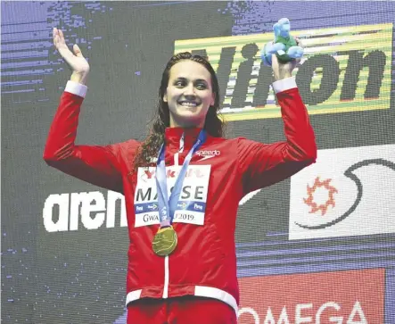  ?? Quinn Rooney/getty images ?? Canada’s Kylie Masse grins during the medal ceremony after winning gold in the 100-metre backstroke final on Tuesday at the FINA World Championsh­ips in Gwangju, South Korea.