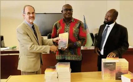  ?? Photo: Festus Hamalwa ?? Read… Judge Dave Smuts handing over books to Ohangwena governor Walde Ndevashiya and education director Isak Hamatwi.