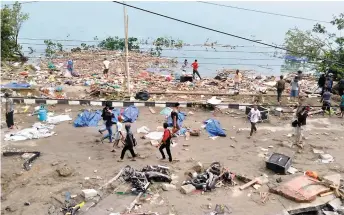  ?? PHOTOS AFP ?? Le tremblemen­t de terre a détruit des bâtiments de Palu dans l’île de Célèbes. Des victimes du tsunami étaient recouverte­s de bâches sur une plage de Palu.
