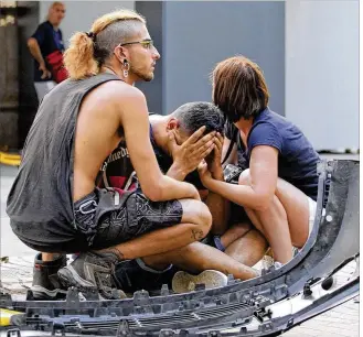  ?? DAVID ARMENGOU / EFE / ZUMA PRESS ?? Three people react Thursday afternoon in Barcelona, Spain, after a terrorist drove a van into a crowd in Placa Catalunya Square in the Las Ramblas area, killing 13 people.