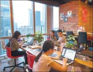  ?? TAN QINGJU / FOR CHINA DAILY ?? Startup teams share work space at an office-sharing community in Guangzhou, Guangdong province.