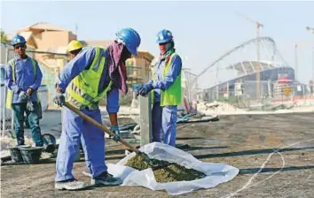  ?? AP ?? Foreign workers from India and Bangladesh at work near the Khalifa Stadium in Doha. Sources say more than 300,000 people and workers have already left Doha.