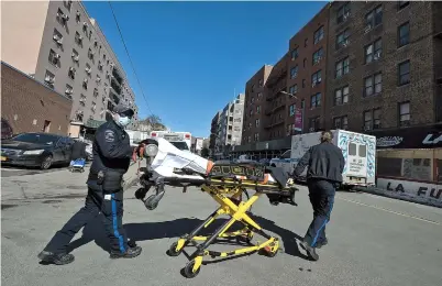 ??  ?? Two emergency medical technician­s return to their ambulance with their stretcher after dropping off a patient at Elmhurst Hospital Center in New York City on Sunday. — CFP