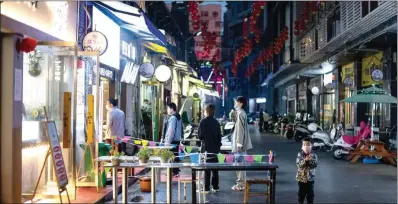  ?? (AFP) ?? People wearing facemasks as a preventive measure against the COVID-19 coronaviru­s queue up to order take out food in Huanggang, in China’s central Hubei province on Thursday.