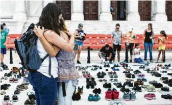  ?? Erika P Rodriguez / New York Times ?? Women embrace at a memorial for victims of Hurricane Maria in San Juan. In a report to Congress, asking for $139 billion in recovery funds, the government said 1,427 people died, not 64.