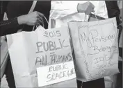  ??  ?? MEMBERS of an anti-poverty group tote brown paper bags during a demonstrat­ion Tuesday outside City Hall before the City Council vote.