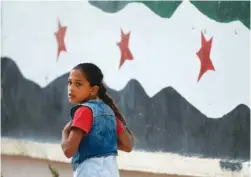  ?? AP PHOTOS BY LEFTERIS PITARAKIS ?? A Syrian girl walks past a hospital in Jarablus, northern Syria, on May 30.