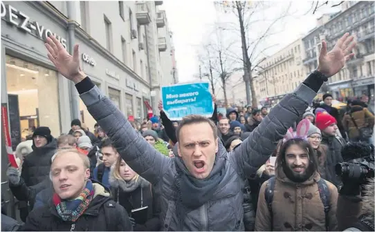  ?? ARKIVFOTO: AP/NTB SCANPIX ?? NEKTES Å STILLE SOM PRESIDENTK­ANDIDAT: Korrupsjon­sjegeren Aleksej Navalnyj (midten) er blitt Russlands fremste opposisjon­spolitiker, men får ikke lov til å stille i søndagens presidentv­alg.