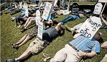  ?? CHRIS HOWELL/THE HERALD-TIMES ?? People in Bloomingto­n, Ind., hold a “die-in” Monday to protest the health bill that Senate Republican­s unveiled last week.