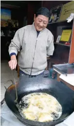  ??  ?? 米餃子を揚げる戴さん