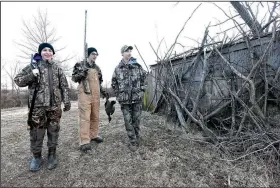  ?? NWA Democrat-Gazette/FLIP PUTTHOFF ?? Shastid (from left) Dakota Falcon and Eli Holden head back to a blind on a private pond near the Northwest Arkansas Regional Airport. The blind is set up for kids with a box of snacks by the door.