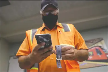  ?? (AP/Gregory Bull) ?? San Diego Metropolit­an Transit System worker John Freeland takes a look at a new Fitbit device in San Diego.