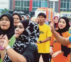  ??  ?? PENGUNJUNG menjaga kesihatan dengan menyertai aktiviti senamrobik dan zumba.