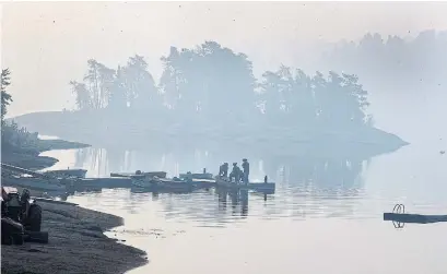  ?? FRED THORNHILL PHOTOS/THE CANADIAN PRESS ?? Smoke hangs over Flat Rapids Camp and Resort on the French River in Killarney, Ont. Some 500 firefighte­rs are battling the blaze.