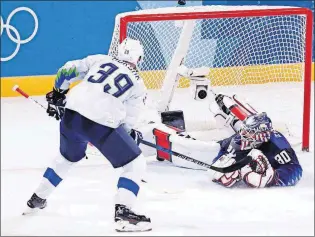  ?? [FRANK FRANKLIN II/THE ASSOCIATED PRESS] ?? Slovenia’s Jan Mursak, left, shoots the puck Wednesday past United States goalie Ryan Zapolski for the game -winning goal during overtime.