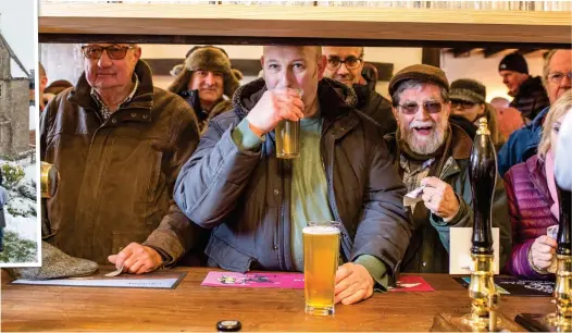  ??  ?? Cheers: Villagers crowd into the Packhorse Inn yesterday to celebrate its reopening after the fundraisin­g campaign