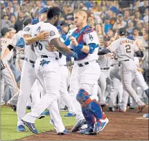  ?? HARRY HOW — GETTY IMAGES ?? The Dodgers’ Yasiel Puig is restrained by Yasmani Grandal and bench coach Bob Geren after an altercatio­n with Giants catcher Nick Hundley.