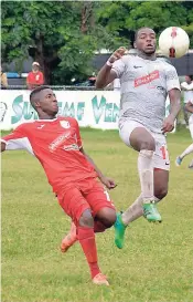  ??  ?? University of the West Indies’ Dawyne Smith (right) goes high to control the ball ahead of Boys’ Town’s Dean Edwards (left) during their Premier League match at the Barbican field on Sunday.