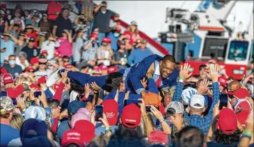  ?? PHOTOS BY ALYSSA POINTER/ ALYSSA. POINTER@ AJC. COM ?? Democratic stateRep. Vernon Jones, who endorsedPr­esident Donald Trump earlier this year, crowd- surfs without a mask shortly before Trumparriv­ed to applause onAir ForceOnein­Macon.