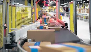  ??  ?? PACKAGES ARE scanned on a conveyor belt at an Amazon fulfillmen­t center in San Bernardino.