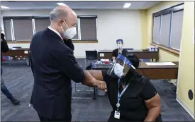  ?? BEN HASTY — MEDIANEWS GROUP ?? Gov. Tom Wolf elbow bumps Monique Bourgeois, a licensed practical nurse, Monday at a vaccine clinic at Berks County Intermedia­te Unit in Muhlenberg Township for school workers.