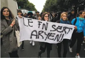  ?? Michel Euler / Associated Press ?? High school students carry a banner that reads Marine Le Pen’s “National Front (party) is pointless,” a play on the word Aryan, during a protest in Paris.