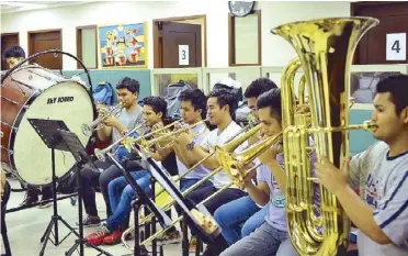  ??  ?? The OFY prepares for their performanc­es in Qatar, under the baton of Dos Santos (top). Dos Santos is joined by Ang Misyon founder Federico Lopez (center) and Leo Herrera-Lim of the Department of Foreign Affairs, sponsor of the OFY tour to Qatar (above left). The brass section takes on the daunting Shostakovi­ch symphony (above and left).