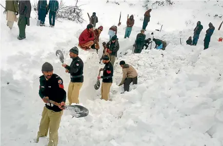  ?? AP ?? Police officers and local residents search for victims of avalanches in Doodnail village in Neelum Valley, Pakistan-administer­ed Kashmir.