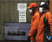  ?? MATT ROURKE - THE ASSOCIATED PRESS ?? Pedestrian­s in protective face mask walk past a closed business in Philadelph­ia, Friday, March 20. Pennsylvan­ia Gov. Tom Wolf directed all “non-life-sustaining” businesses to close their physical locations late Thursday and said state government would begin to enforce the edict starting early Saturday.