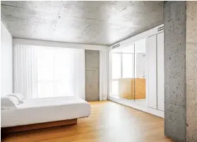  ??  ?? A raised floor and lowered ceiling separate the bathroom from the bedroom (right). The sleek aesthetic extends to the water closet (left).