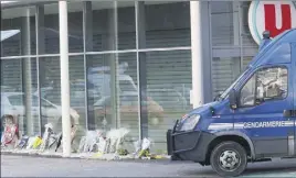  ?? (Photo PQR/L’Independan­t/Claude Boyer) ?? Des fleurs ont été déposées sur les lieux de l’attaque, un supermarch­é U.