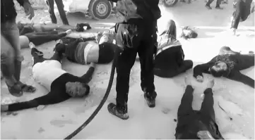  ??  ?? A still image taken from a video posted to a social media website, shows people lying on the ground, after what rescue workers described as a suspected gas attack in Idlib, Syria. — Reuters photo