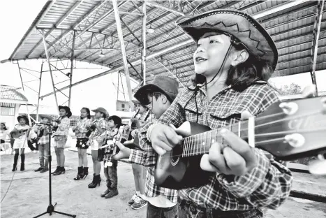  ?? MACKY LIM ?? UKELELE RHYTHM. Pupils of Bunawan Aplaya Elementary School wow visitors from Steel Asia Manufactur­ing Corp. during yesterday’s turnover of equipment to their school as part of the company’s corporate social responsibi­lity.
