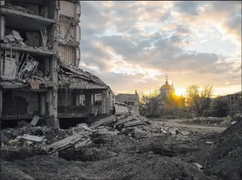  ?? Bram Janssen The Associated Press ?? The sun sets over a destroyed building Tuesday in Izyum, eastern Ukraine. Ukrainians are bracing for another winter of Russian attacks on energy infrastruc­ture.
