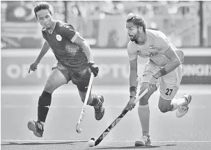  ?? — Gambar AFP ?? SENGIT: Pemain India, Akashdeep Singh (kanan) dan pemain Malaysia, Ramadan Rosli of Malaysia bersaing pada perlawanan di Gold Coast, Australia semalam.