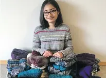  ??  ?? Allysa Narang, 13, with the hats she knit and donated.