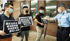  ?? KIN CHEUNG/AP ?? SUARA PENOLAKAN: Anggota Partai Demokrat memegang poster bernada protes di depan kantor perwakilan Tiongkok di Hongkong kemarin. Mereka merasa UU Keamanan Nasional segera mengakhiri prinsip satu negara dua sistem.