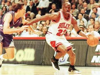  ?? — AFP photo ?? Chicago Bulls player Michael Jordan goes past Jeff Hornacek of the Utah Jazz during game two of the NBA Finals at the United Center in Chicago, IL, in this June 4, 1997 file photo.