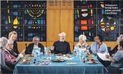  ??  ?? Volunteers bring Seder joy to a Jewish Care home