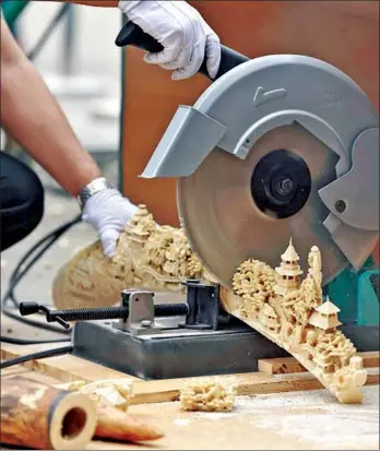  ?? LI XIN / XINHUA ?? Law enforcemen­t officers destroy confiscate­d tusks and ivory carvings at the Beijing Wildlife Rescue and Rehabilita­tion Center.