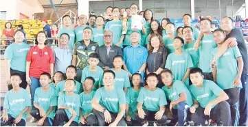  ??  ?? OUTSTANDIN­G FEAT: SSMS swimmers and officials pose with Datu Roslin (5th left, standing) after the prize presentati­on of the MSSS Swimming Championsh­ip in Likas on Tuesday.